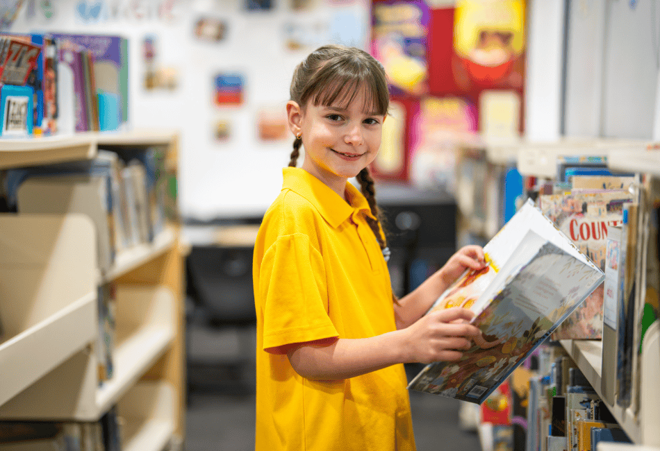 A photo of a St Thomas More’s Catholic Primary School Brighton-Le-Sands student reading in the library and on the way to 2025 NAPLAN results success